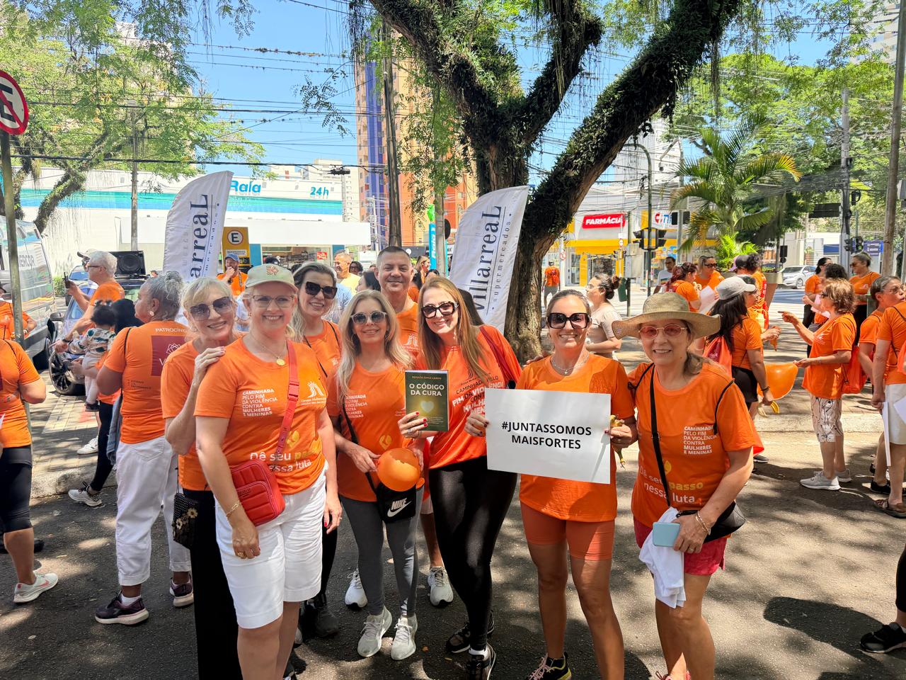 Foto de caminhada de conscientização com participantes usando camiseta laranja